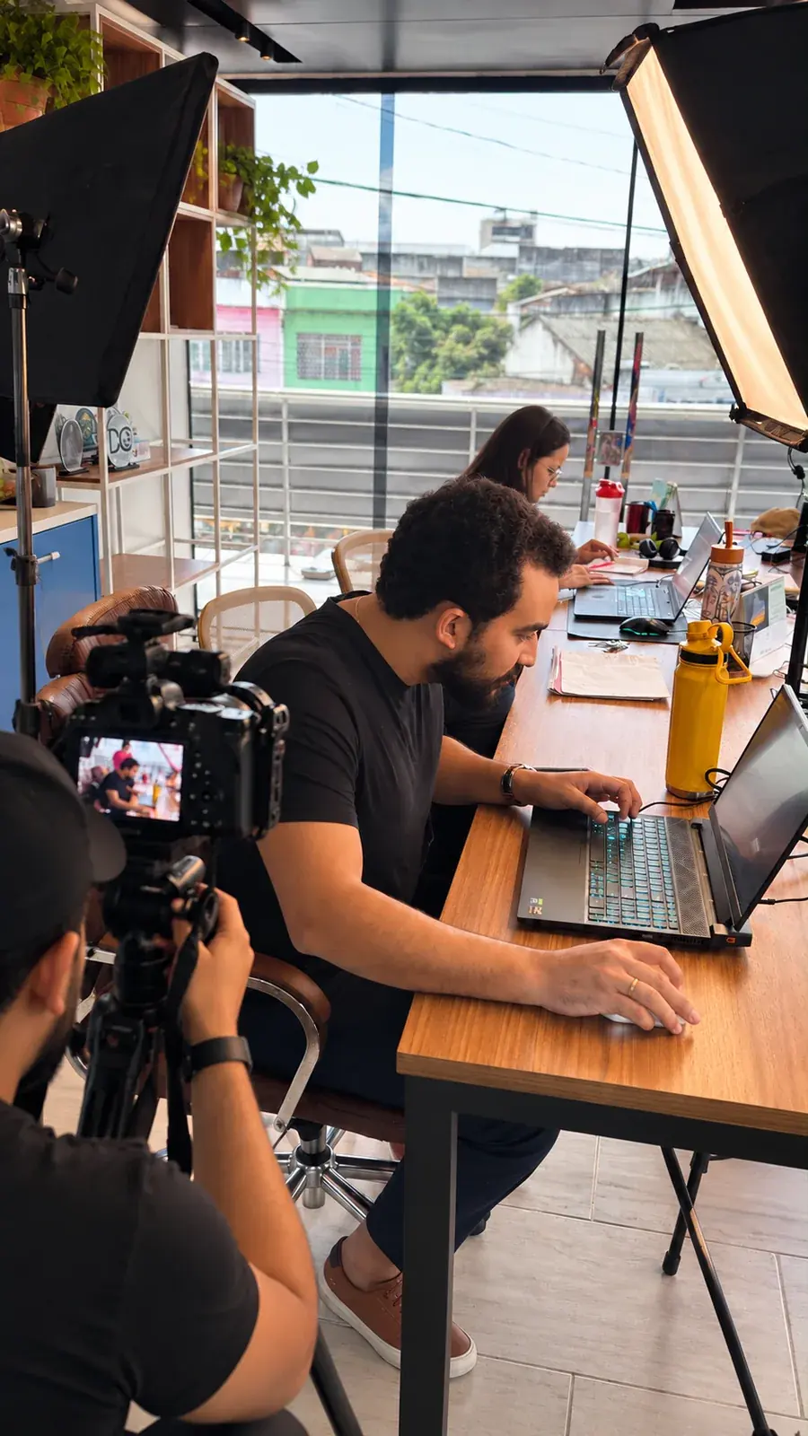Winicius Ivan trabalhando em estratégias digitais, com produção audiovisual ao fundo